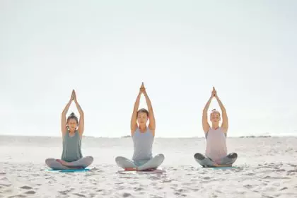 Zen, meditation and yoga at the beach with women for wellness, fitness and health. Stretching, lotu